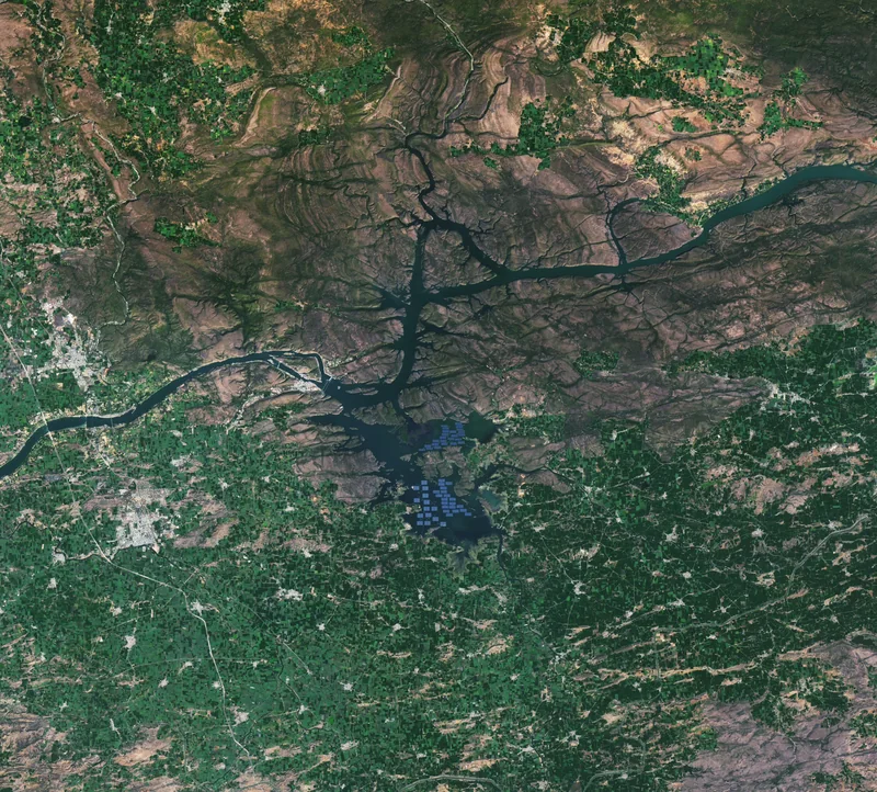 Landsat से ओंकारेश्वर जलाशय का पूरा दृश्य, पानी में नीले आयताकार सौर पैनल समूह