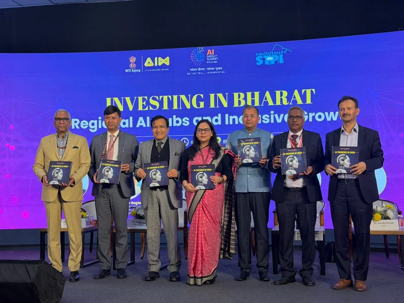 मंच पर AI-Preneurs of India किताब दिखाते छह अतिथि